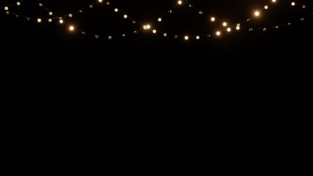String lightbulb on black background, glowing gold lights.