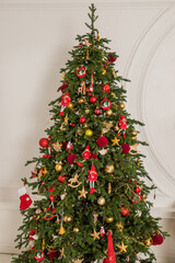 Big christmas tree decorated with beautiful red, golden baubles at home. Copy space. celebrate christmas, new year. ready for winter holidays, beautifully decorated with christmas tree