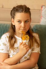A girl with a sugar lollipop in the shape of a cockerel