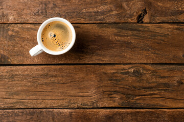 Coffee cup on vintage wooden table with copyspace. Top view