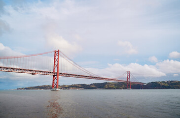 Beautiful landscape with suspension 25 April bridge bridge over the Tagus river in Lisbon, Portugal.