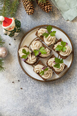Creative appetizer christmas. Creamy pate sandwiches of herring on a rye bread on the festive table. View from above. Copy space.