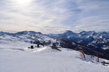 Stunning view of snowy Italian mountain range and valley from ski slope in Sauze D'Oulx ski resort,...