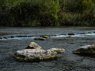 rivière avec rocher et petite cascade sur fond de couleurs d'automne