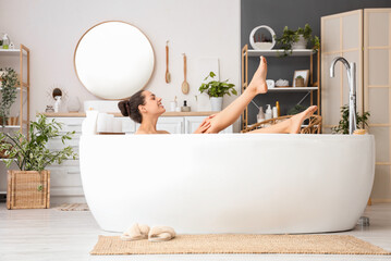 Young woman taking bath at home - obrazy, fototapety, plakaty