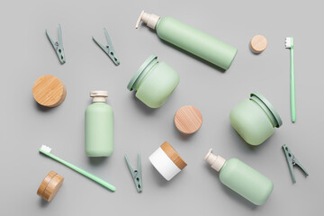 Composition with different cosmetic products, toothbrushes and clothespins on grey background