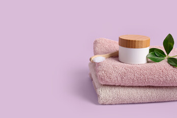 Fototapeta na wymiar Clean towels, cosmetic product and toothbrush on lilac background