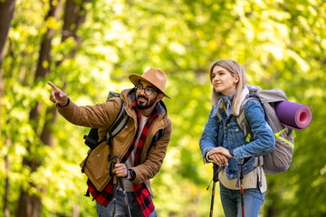 Young couple hiking and discussing the route
