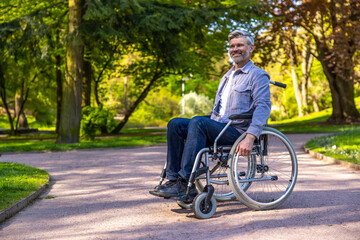 Gray-haired man on a wheelchair in a park