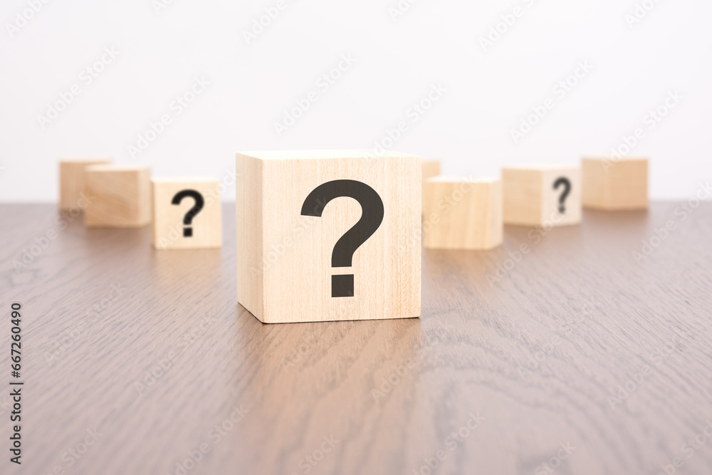 Poster question marks blocks stand on wooden background with copy space