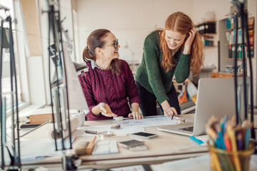 Two female architects working on a project together in a modern office