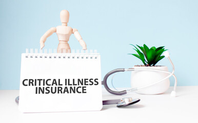 The text CRITICAL ILLNESS INSURANCE is written on notepad and wood man toy near a stethoscope on a...
