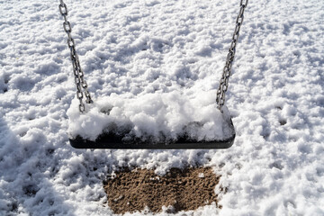 Snow covered swing in the playground