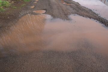 Broken road with brown rainwater