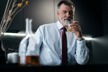 Confident rich mature wealthy businessman chilling relaxing drinking enjoying whiskey in the...