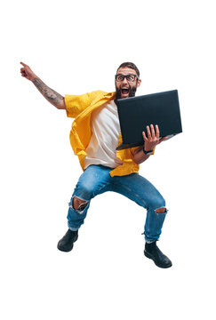 Jumping crazy programmer, web developer or designer holding laptop in his hands and pointing to your text. Discount, sale, season sales. Shocked or surprised facial expression. Funny promotion poster.