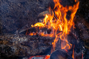  Intense bonfire with dramatic red and orange flames against a dark backdrop.