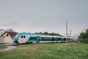 Long modern diesel train, triple units of blue and white train in early morning commute service in Ljubljana, Slovenia. Typical morning route to Kamnik.