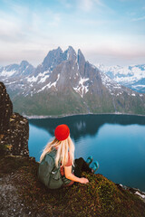 Fototapeta na wymiar Tourist woman traveling in Norway alone enjoying fjord view hiking in mountains outdoor with backpack healthy lifestyle adventure vacations female traveler exploring Senja island
