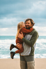 Father and daughter hugging together family lifestyle outdoor child with daddy walking on the beach summer vacations happy candid emotions parent and kid love concept