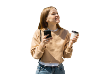 A young woman is walking, drinking coffee from a cup and using her phone. Enjoying spending time alone.