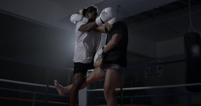 Fighter defeating opponent in takedown inside boxing ring captured in high-speed at 800 fps with speed-ramp