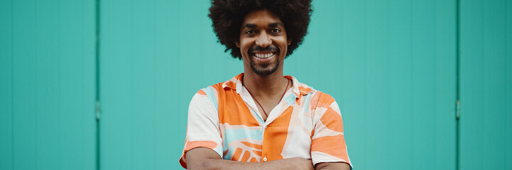 Close-up frontal portrait of cheerful young African American man wearing shirt smiling at the...
