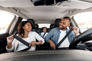 Happy african american family enjoying car ride together - obrazy, fototapety, plakaty