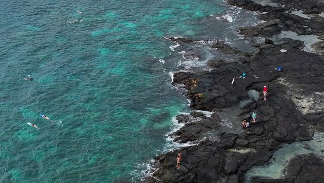 Aerial ocean Two Step swimming beach Kona Hawaii slide 2. Beautiful cove bay blue Pacific ocean water. Snorkel and scuba dive vacation destination. Black volcanic lava rock. Recreation and relaxation.