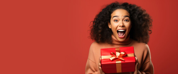 Excited woman opening a present - obrazy, fototapety, plakaty