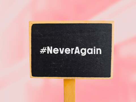 the hashtag Never again written on chalk board to strict gun control laws after mass shootings in the United States.