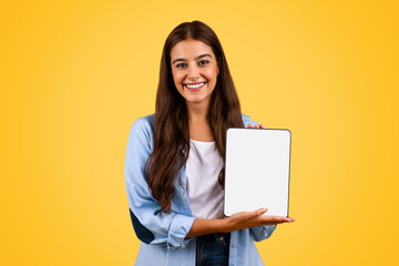 Positive european young student lady show tablet with empty screen