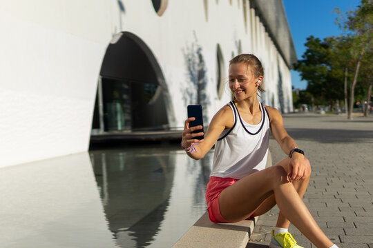 A young running girl is looking at her cell phone