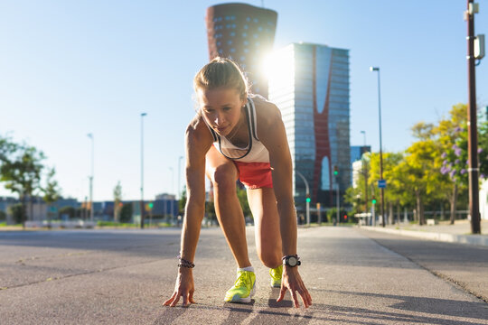 A woman running down a sidewalk in a city