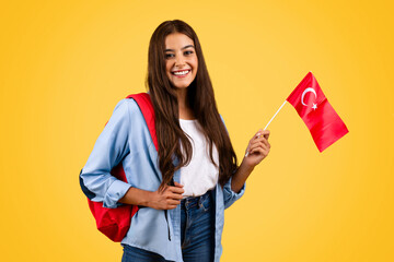 Smiling european young student woman, with Turkish flag, combines patriotism with education