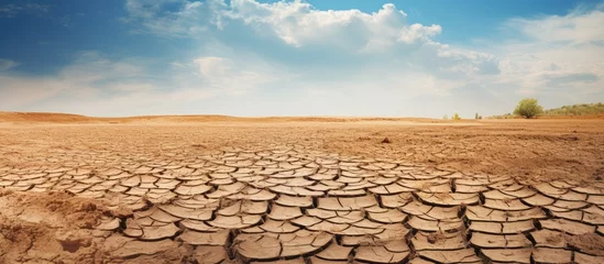 Deurstickers Drought and climate change lead to cracked and dry soil revealing water shortage and climate crisis © 2rogan