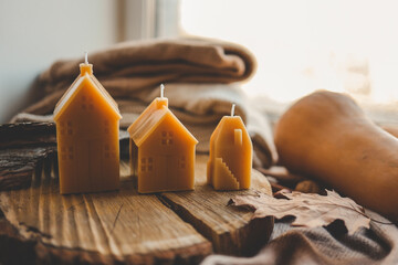 Handmade candles in the shape of a house in an autumn interior