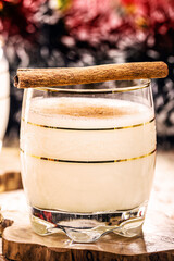 winter drink made with eggs, liqueur, rum and cinnamon, called Christmas eggnog, decorated with nuts, cookies and dried fruit
