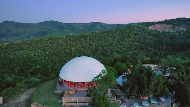Mountain top restaurant in Siquijor island, Philippines. Cinematic drone fly by. Aerial view at dusk above Cangbangsa and Larena towns. Famous travel destination.