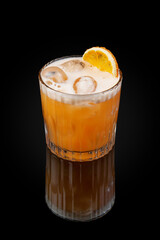Alcoholic cocktail based on tequila, aperol, passion fruit puree and grapefruit juice and egg white. Drink in a glass on dark background with reflection