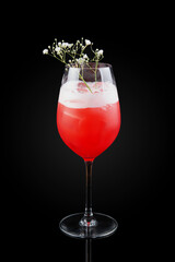 Bright sweet-sour bitter cocktail with Campari, vermouth and grapefruit juice based on the progenitor of Negroni - Milano-Torino cocktail. Drink in a glass on dark background with reflection