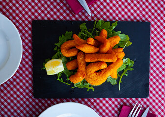 Fried sepia in a batter of tempera flour with lemon and arugula