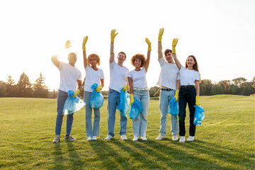 Obraz premium multiracial group of people volunteers in gloves with garbage bags collect garbage and plastic in the park and greet