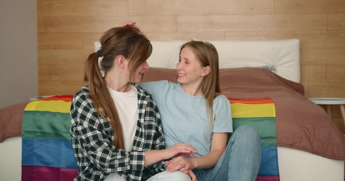 Lgbtq female couple hugging while being at home