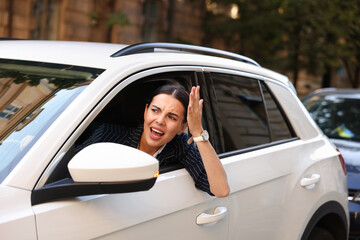 Angry driver screaming at someone from car in traffic jam