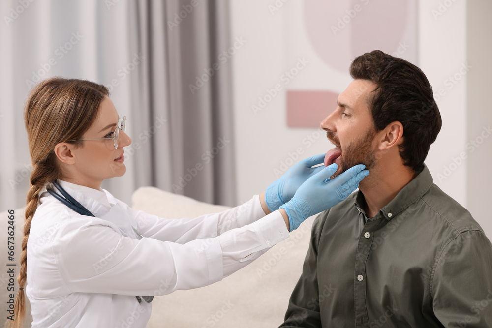 Canvas Prints Doctor in gloves examining man`s oral cavity indoors