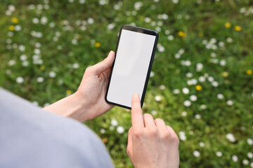 Woman using mobile phone outdoors, closeup view