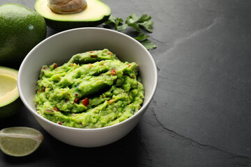 Delicious guacamole, fresh avocado and parsley on grey table. Space for text
