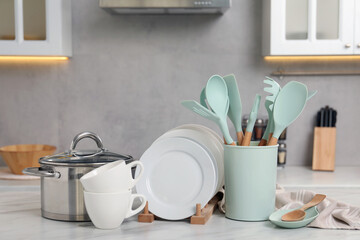 Set of different kitchenware on white table at home