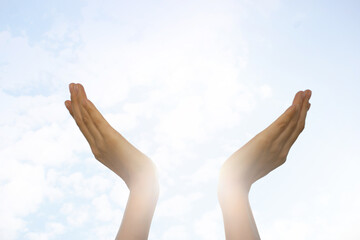 Feeling freedom. Woman reaching for sky on sunny day, closeup of hands Space for text